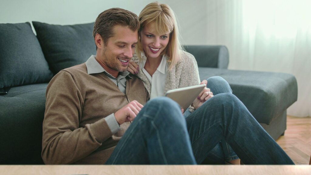 Pärchen arbeitet zuhause digital mit dem Tablet.